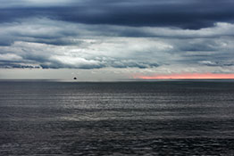 Ostsee bei Sonnenaufgang mit Schiff und Wolken